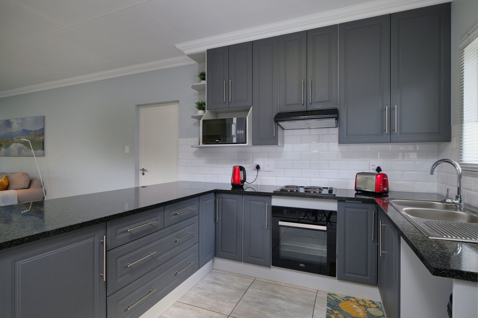 Sleek modern kitchen with grey cabinets, appliances, and stylish decor.